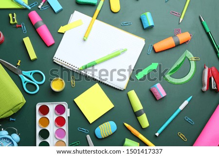 Different bright school stationery on green background, flat lay