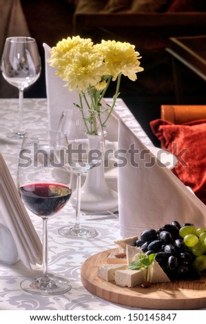 Wine and grapes and cheese on the table in a restaurant