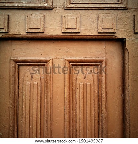 closeup intricate shaped door in brown paint geometric shapes