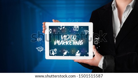Young business person working on tablet and shows the inscription: VIDEO MARKETING