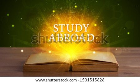 STUDY ABROAD inscription coming out from an open book, educational concept