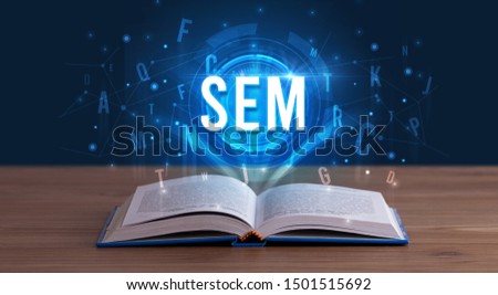 SEM inscription coming out from an open book, digital technology concept
