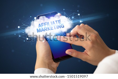 Female hand touching smartphone with AFFILIATE MARKETING inscription, cloud business concept