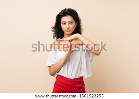 Young woman over isolated background making time out gesture