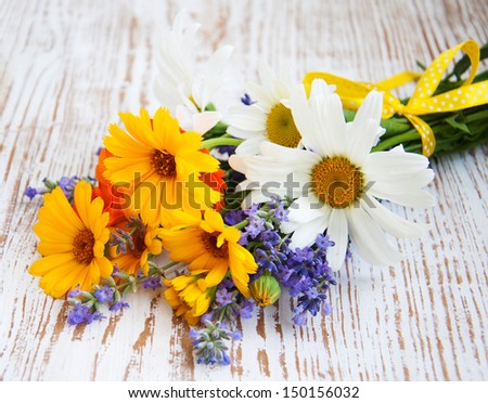 bouquet of calendula, daisy and lavender  flowers on a wooden background