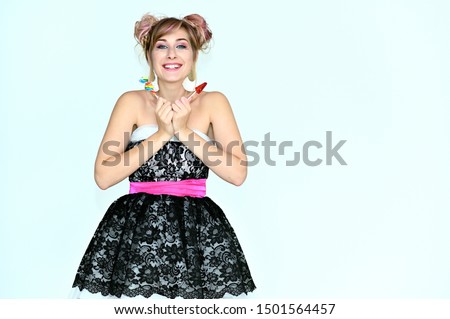 Portrait of a cute happy funny blonde girl with colored hair on a white background with candy in her hands. Smiling in various poses, beauty, holiday.