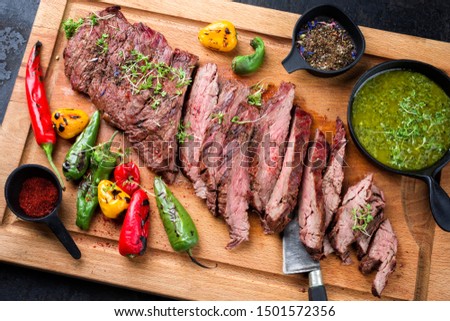 Modern design barbecue dry aged wagyu bavette de flanchet steak with chili and chimichurri sauce as top view on a wooden cutting board  Royalty-Free Stock Photo #1501572356
