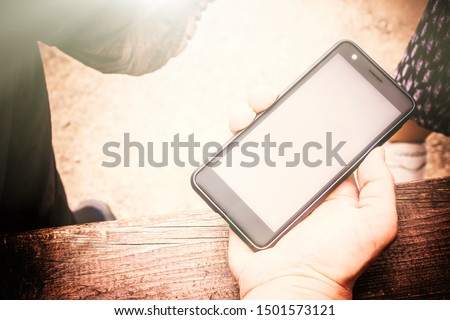 smartphone in the hand of a man. man using a mobile phone, blank screen, top view. tint