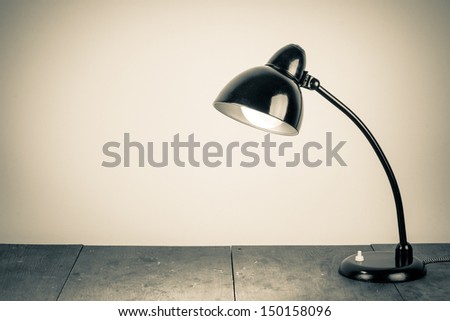 Vintage background with lighting retro desk lamp on wood table Royalty-Free Stock Photo #150158096