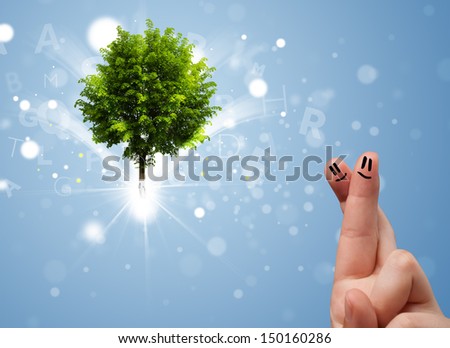 Happy finger smileys faces on hand with green magical glowing tree
