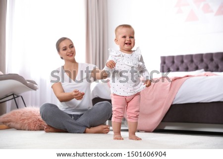 Mother spending time with her baby in bedroom