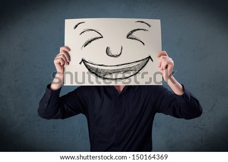 Businessman holding a paper with a drawed smiley face on it in front of his head