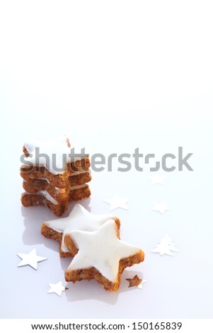 Delicious star shaped ginger biscuits for Christmas or Advent frosted in white icing with copyspace for your seasonal greeting