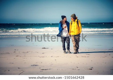 Two beautiful happy young girls travel on Lofoten islands in Norway, trekking and hiking, active lifestyle, lesbian family