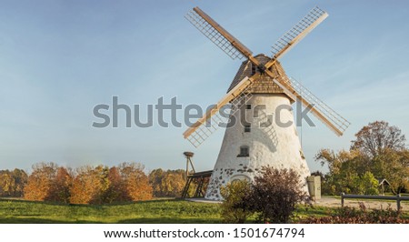Restored old windmill on the mountainside. Autumn sunny day.