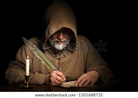 mysterious medieval monk writes letter Royalty-Free Stock Photo #1501688735