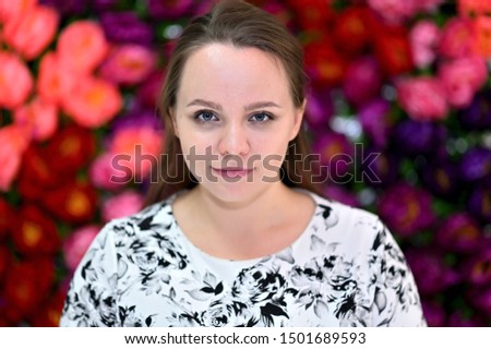 Portrait of a pretty young woman on a colorful background in a light dress. Right in front of the camera in various poses.