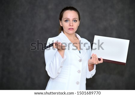 Portrait of a pretty manager woman on a gray background in a white business suit with a folder in her hands. Standing right in front of the camera in various poses.