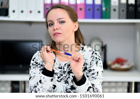 Business portrait of a pretty young woman secretary in the office in a light dress. Sitting, talking right in front of the camera in various poses.