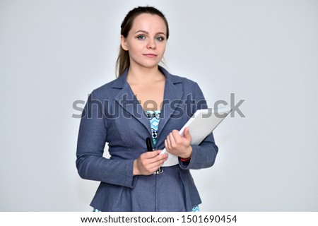 Portrait of a pretty manager woman on a white background in a gray business suit with a folder in her hands. Standing right in front of the camera in various poses.