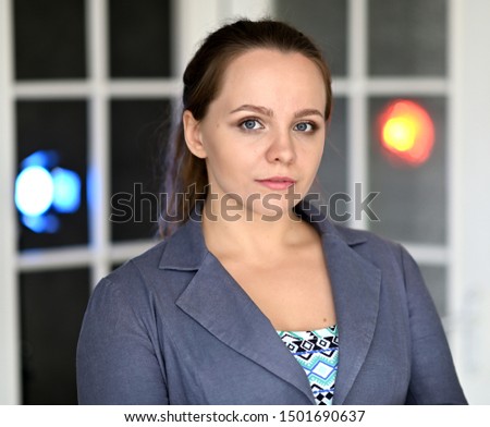 Portrait of a pretty manager woman on a dark background in a gray business suit. Standing right in front of the camera in various poses.