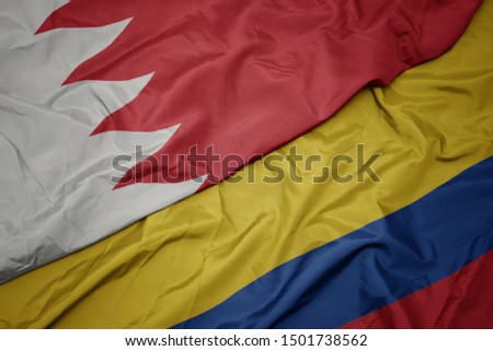 waving colorful flag of colombia and national flag of bahrain. macro