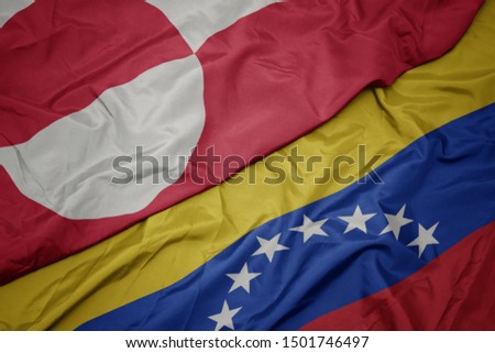 waving colorful flag of venezuela and national flag of greenland. macro