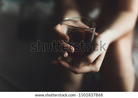 woman holds glass with whiskey. alcohol cocktail in glass. woman's alcoholism, alcohol addict concept Royalty-Free Stock Photo #1501837868