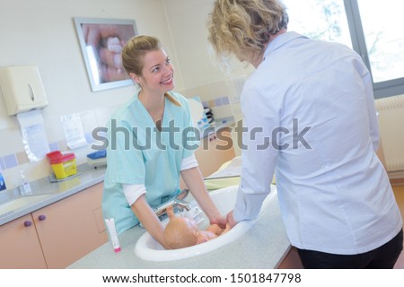 a newborn baby is having her first bath