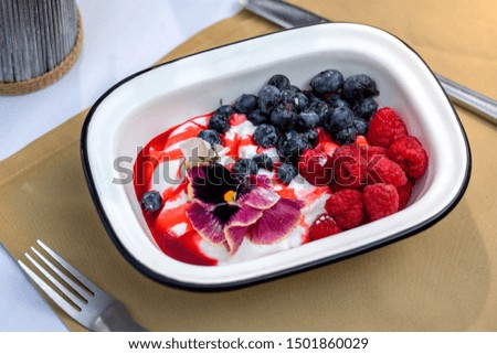 Vanilla ice cream dessert with fresh blueberries and raspberries. Close up top view.