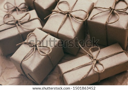 Many parcels wrapped in brown craft paper and tie hemp string. Crumpled background. Presents set. Delivery parcels. Online shopping. 