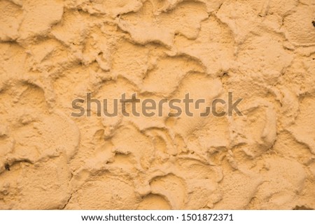 Texture with irregular yellow plaster.
