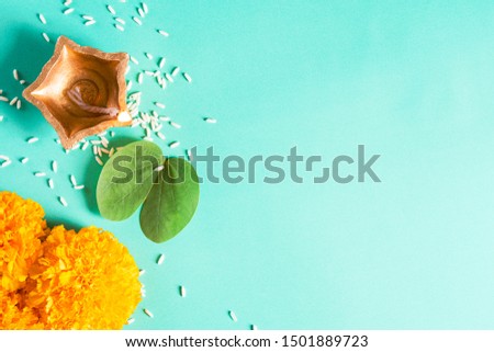 Happy Dussehra. Clay Diya lamps lit during Dussehra with yellow flowers, green leaf and rice on green pastel background. Dussehra Indian Festival concept. Royalty-Free Stock Photo #1501889723