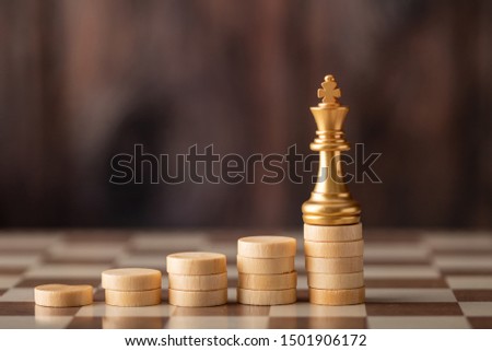 gold king on the step chip on board and wooden background. The winner concept.