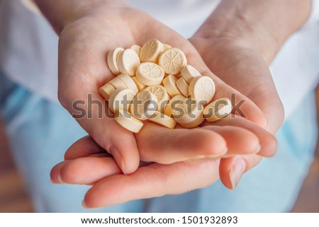 A woman holds vitamins pills in her hands. Vitamin C provides an essential nutrient for healthy bones, cartilage, teeth, and gums. An antioxidant for the maintenance of good health Royalty-Free Stock Photo #1501932893