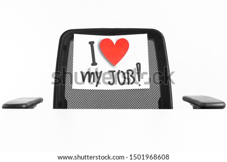 I love my job concept. Sign with a heart hanging on a chair with empty desk and white background. Empty space for text.