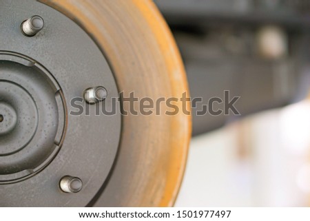 Disc brake of the vehicle for repair, in process of new tire replacement. Car brake repairing in garage.Suspension of car for maintenance brakes and shock absorber systems.Close up.        