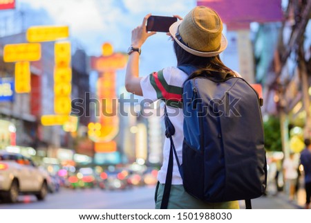 woman tourist taking action of shot photo in Chinatown of Bangkok, Yaowarat, famous and popular place place in Bangkok