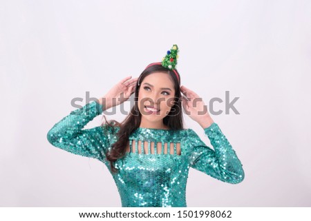 Happy young beautiful woman with Christmas tree on her hair on isolated background