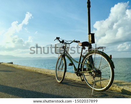 Vintage bicycle at the beach on a sunny day, cloudy blue sky background
