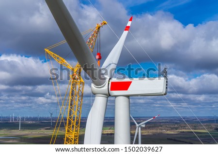 Wind turbine during installation of the star with rotor blades Aerial photograph and close-up view Royalty-Free Stock Photo #1502039627