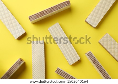 Tasty wafer sticks on yellow background, flat lay. Sweet food Royalty-Free Stock Photo #1502040164