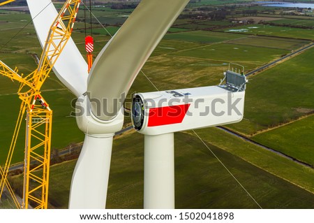 Wind turbine during installation of the star with rotor blades Aerial photograph and close-up view Royalty-Free Stock Photo #1502041898