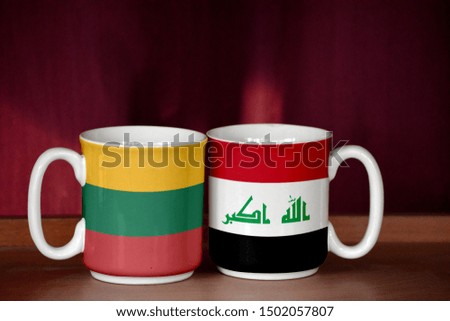Iraq and Lithuania flag on two cups with blurry background