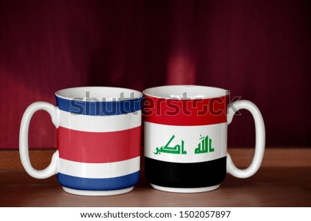 Iraq and Costa Rica flag on two cups with blurry background