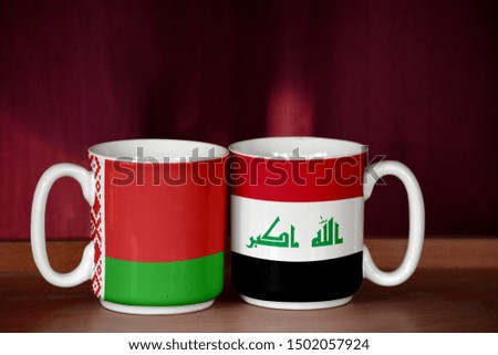 Iraq and Belarus flag on two cups with blurry background
