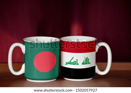 Iraq and Bangladesh flag on two cups with blurry background