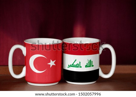 Iraq and Turkey flag on two cups with blurry background
