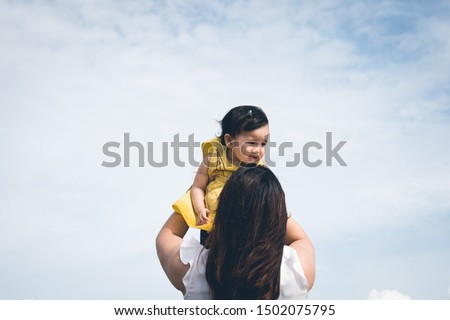 mom and daughter play on blue sky backgroud