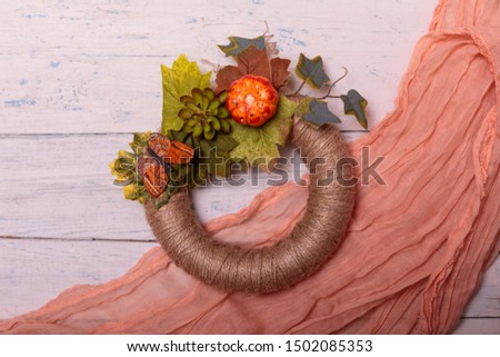 Handmade autumn flower wreath on rustic wooden fence with velvet material